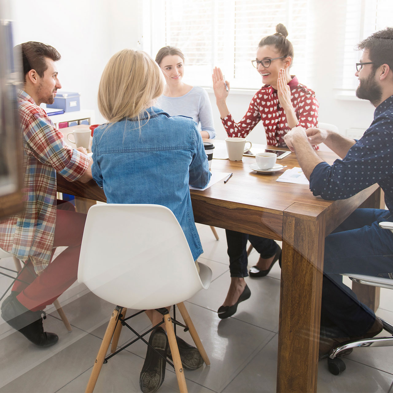 Un groupe d'enseignante et d'enseignant est en train de discuter et travailler autour d'une table.